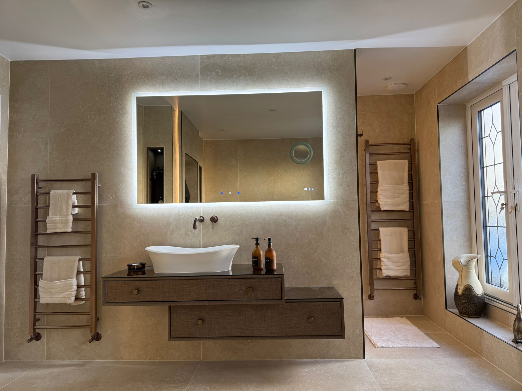Luxury bathroom installation with floating vanity unit, illuminated mirror and towel radiators by MDS Plumbing in Gosforth.