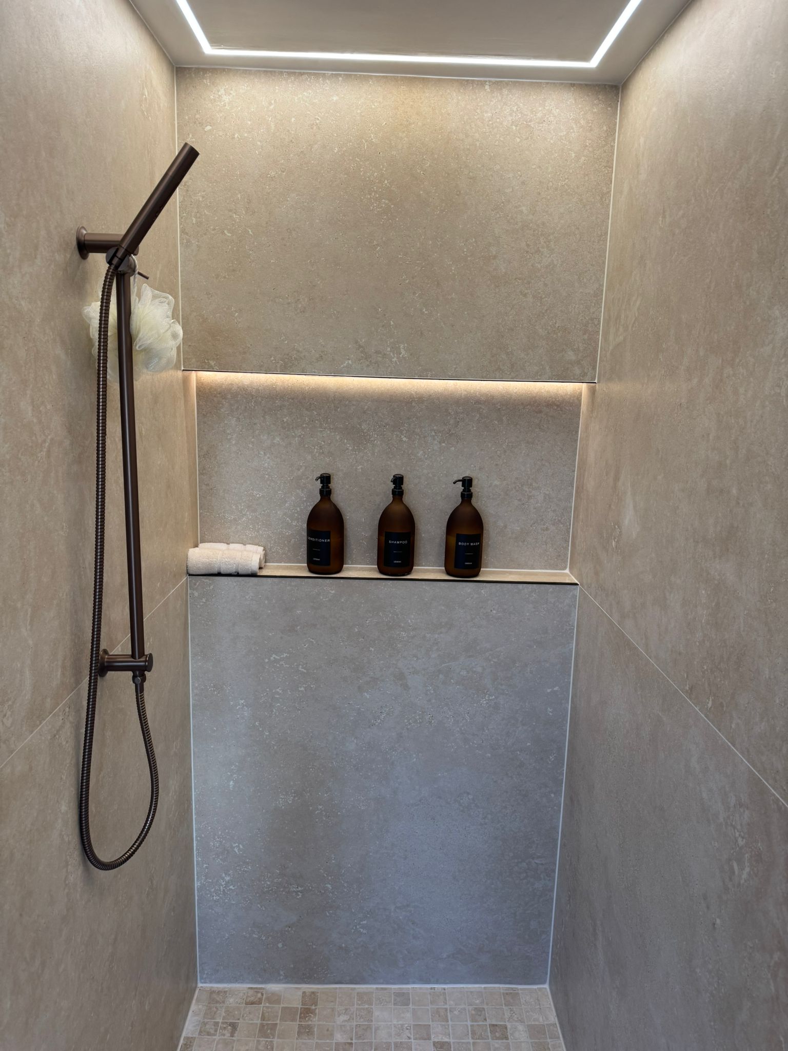 Luxury walk-in shower installation with recessed shelf and LED feature lighting by MDS NE