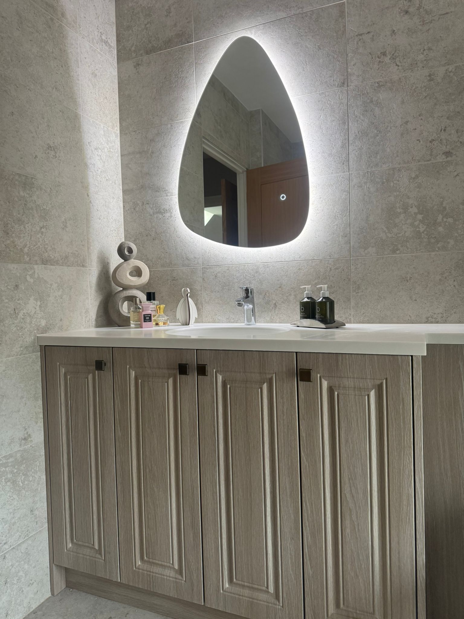 Luxury bathroom vanity unit with illuminated mirror and stone-effect tiles installed by MDS NE