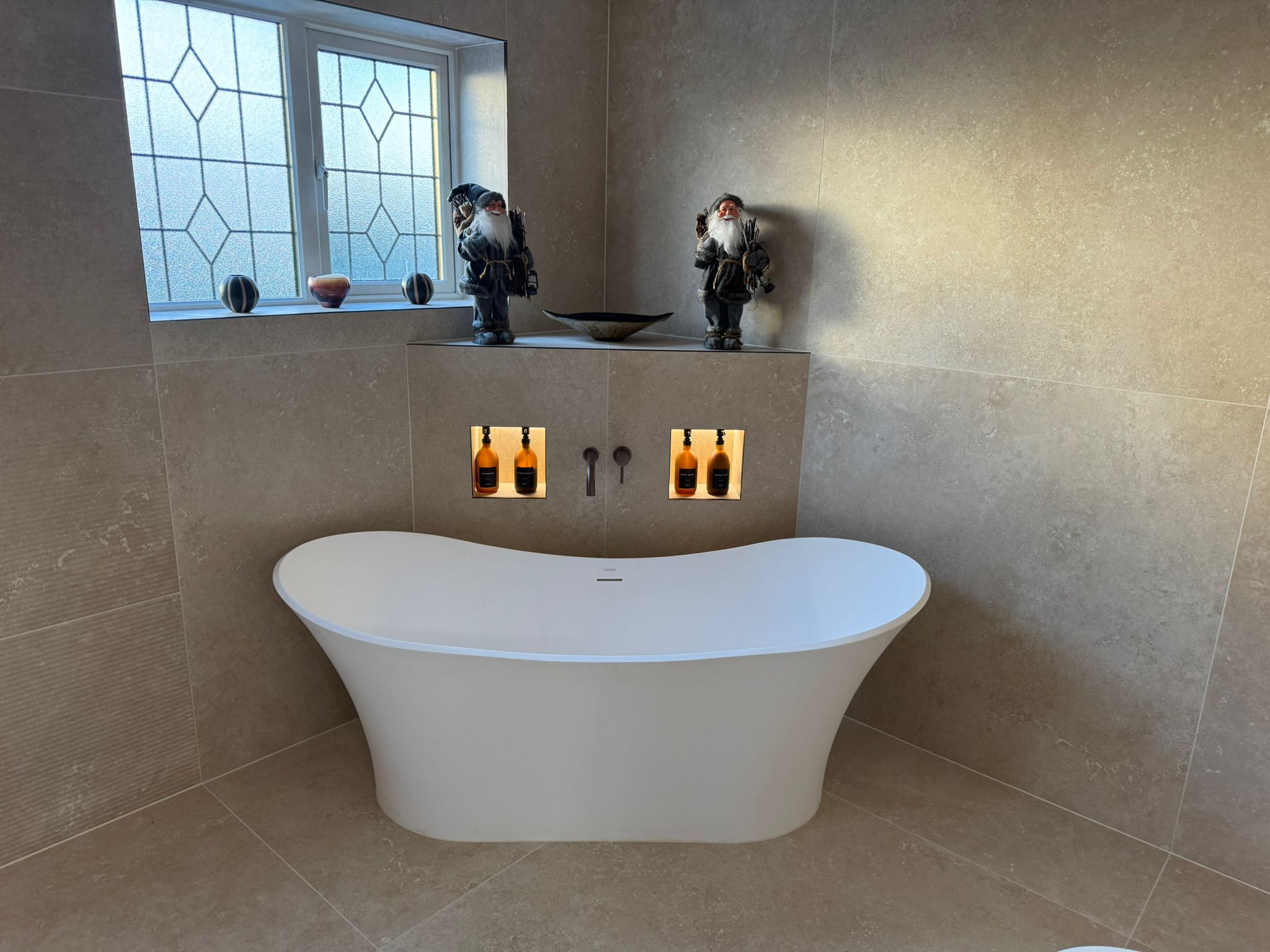 Luxury bathroom installation with freestanding bath and illuminated wall niches by MDS NE