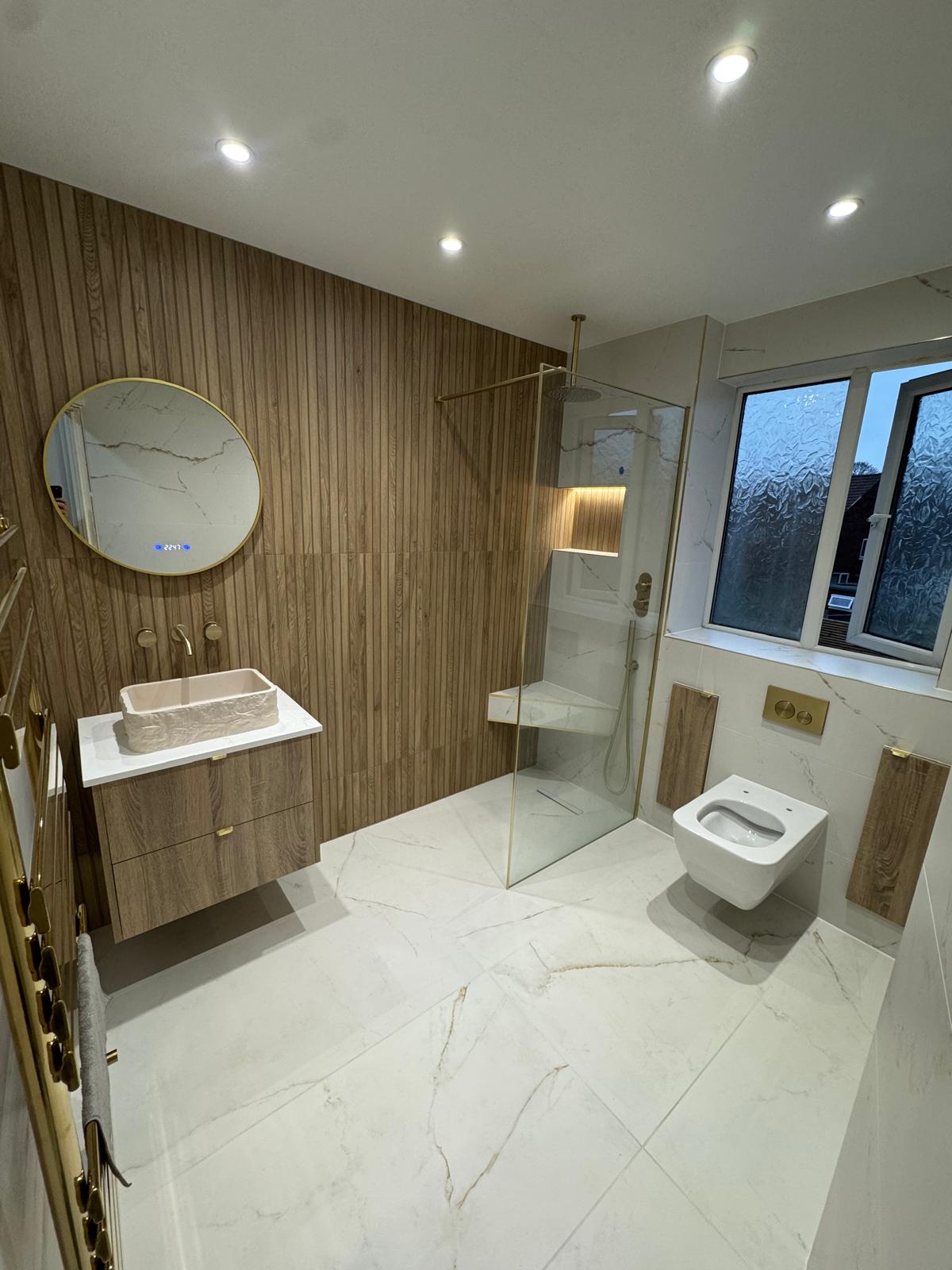 Luxury bathroom renovation with walk-in shower, floating vanity and brushed brass finishes by MDS NE