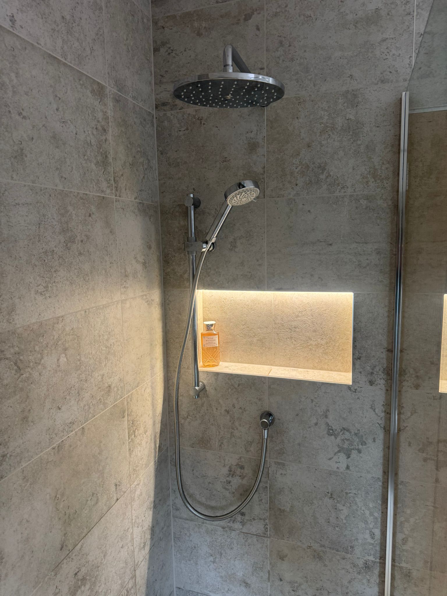 Walk-in shower installation with rainfall shower and illuminated storage niche by MDS NE