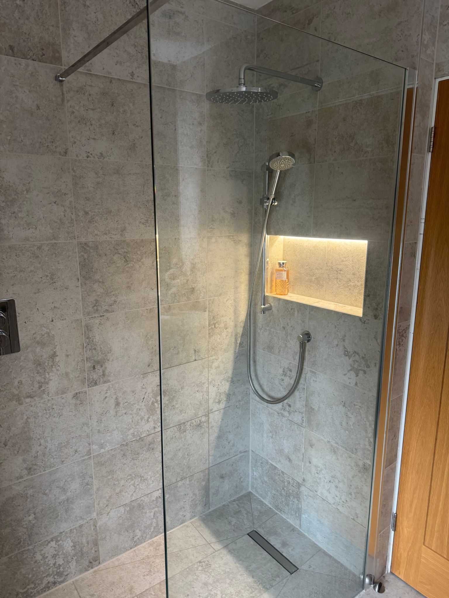 Luxury wet room shower with glass screen, linear drain and illuminated niche by MDS NE